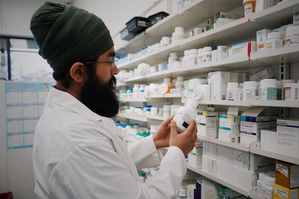 A pharmacist carefully checking a medication against the shelves